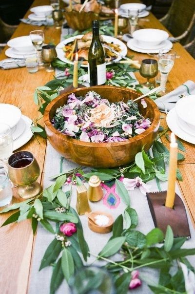 Feestelijk gedekte tafel met gedeelde schalen, bloemen en wijnglazen